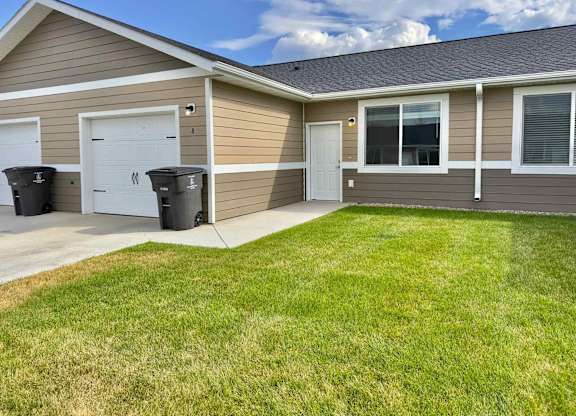 A house with a brown siding and a white door is shown.