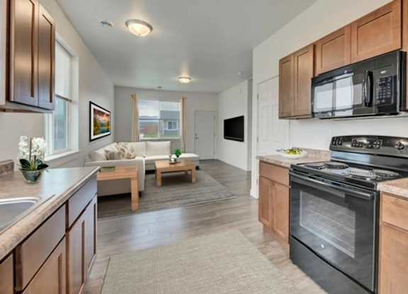 A kitchen with a black oven and microwave above it.