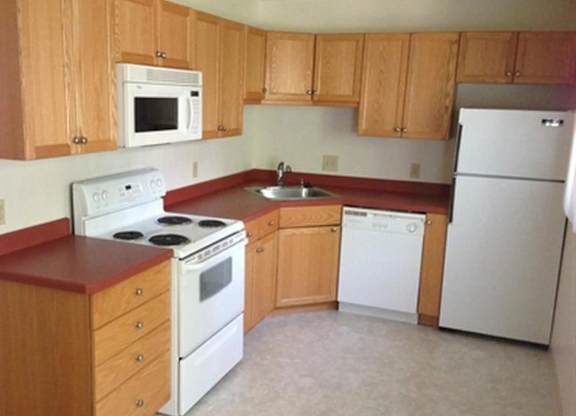 A kitchen with white appliances and wooden cabinets.