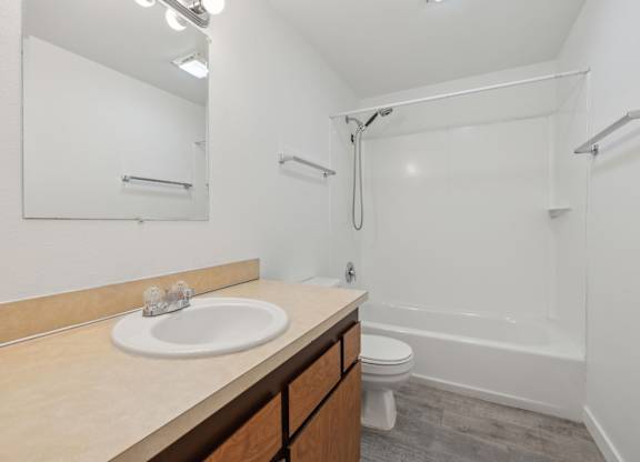 A bathroom with a sink, toilet, and bathtub.