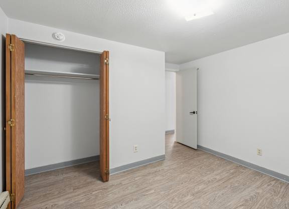 A room with a white wall and a wooden door.