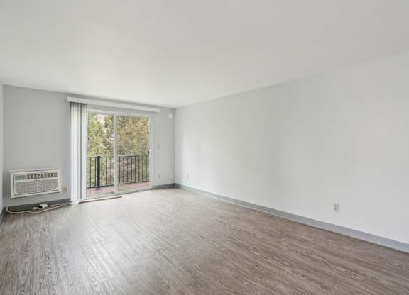 A room with a sliding glass door leading to a balcony.