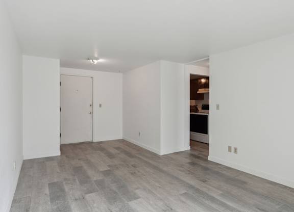 A room with a white door and a grey floor.