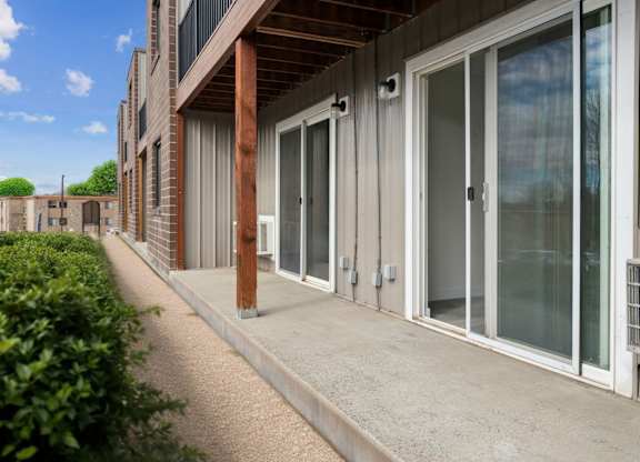 A building with a concrete walkway and glass doors.
