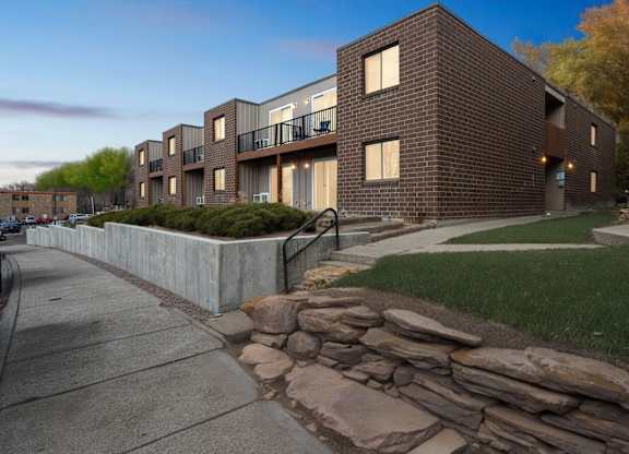 A modern brick building with a stone wall in front.