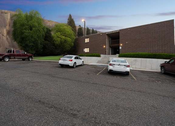 A parking lot with a red truck, a white car, and a brown car.