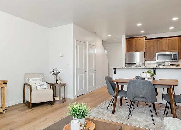 A modern living room with a flat screen TV and a dining area.