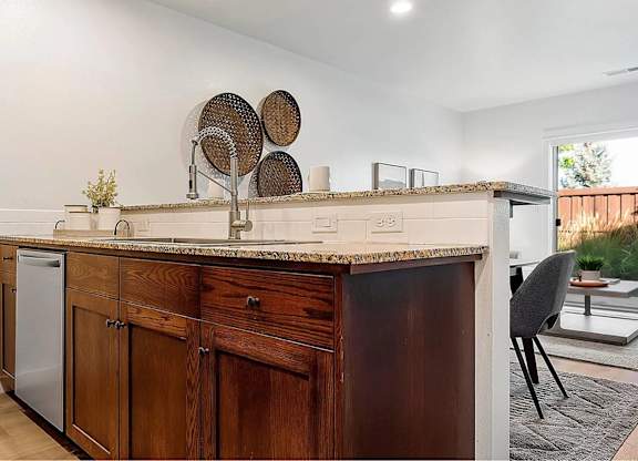A kitchen with wooden cabinets and a marble countertop.