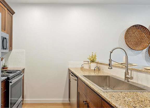 A kitchen with a stainless steel refrigerator and wooden cabinets.