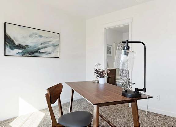 A table with a chair and a lamp on it.
