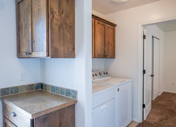 A kitchen with a white stove and wooden cabinets.