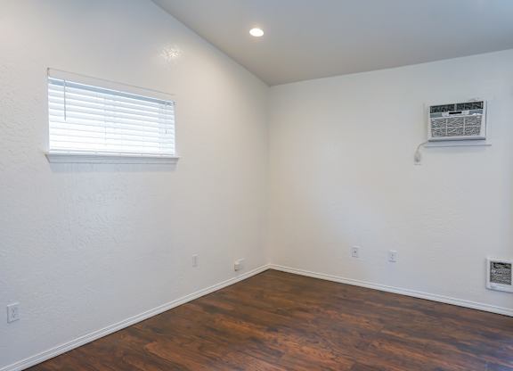 A room with a window and a wall-mounted air conditioner.