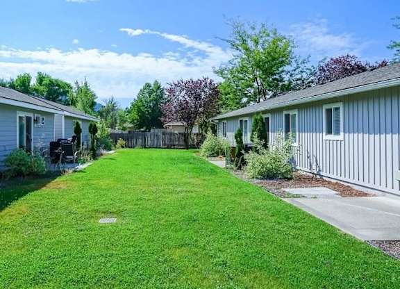 A grassy area in front of a row of houses.