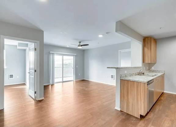 A kitchen with a wooden island and a ceiling fan.
