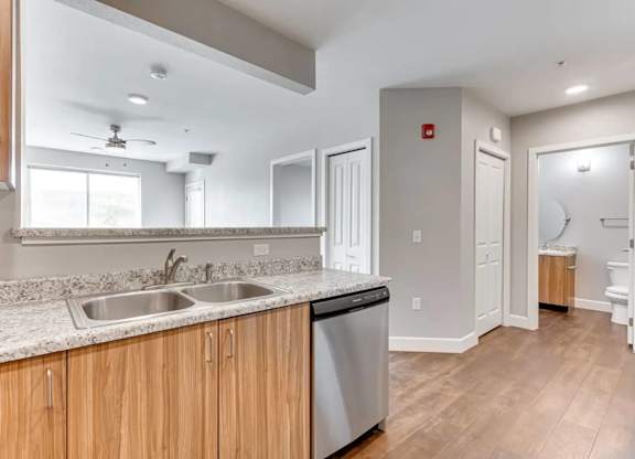 A modern kitchen with wooden cabinets and a marble countertop.