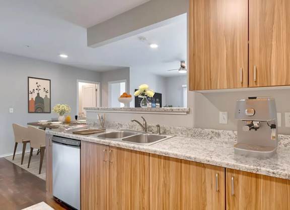 A kitchen with wooden cabinets and a marble countertop.