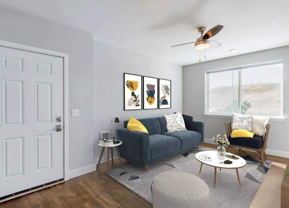 A living room with a grey couch, a white table, and a white door.