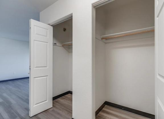 A white door is open to a small, empty room with a shelf.