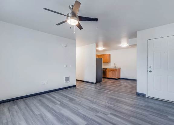 A room with a ceiling fan and a wooden cabinet.