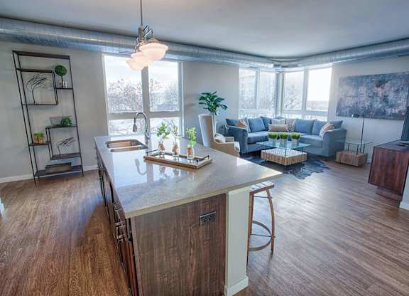 A kitchen with a wooden island and a dining area with a blue couch.