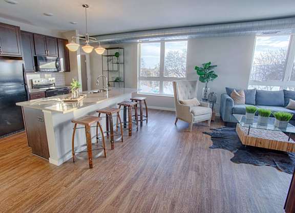 A kitchen with a bar and chairs.