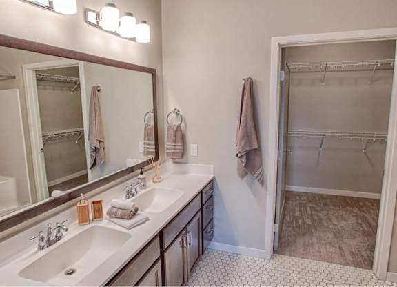 A bathroom with a sink, mirror, and a walk-in shower.