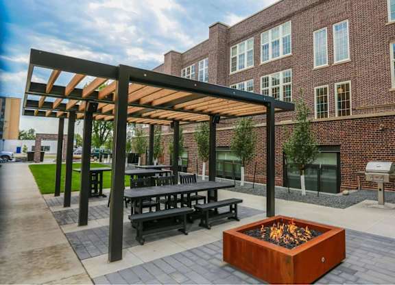 A modern outdoor seating area with a fire pit in the center.