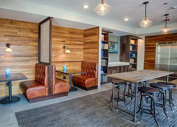 A room with a wooden wall and a table with chairs.