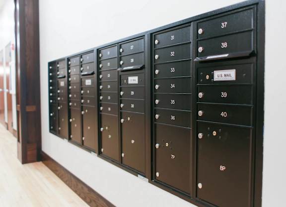 A row of mailboxes are lined up on a wall.