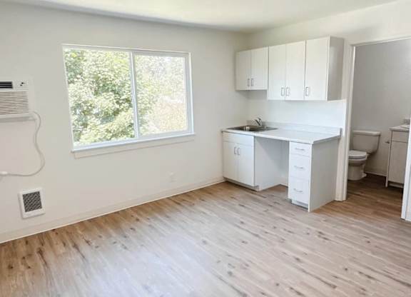 A room with a window, a desk, and a cabinet.