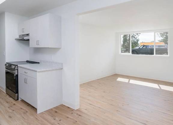 A kitchen with white cabinets and a black stove top oven.