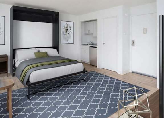 A bedroom with a large bed and a patterned carpet.