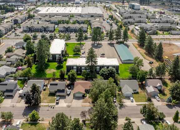 A bird's eye view of a residential area with houses, a large building, and a parking lot.