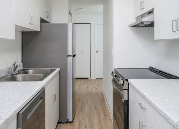 A kitchen with white cabinets and stainless steel appliances.
