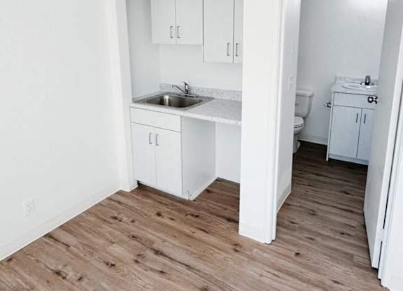 A kitchen with white cabinets and a sink.