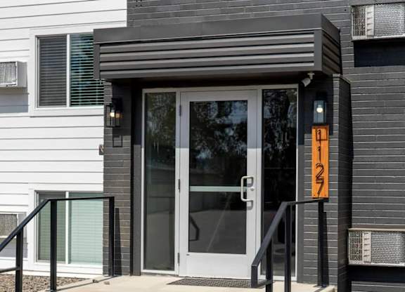 A black house with a glass door and a number 127 on the door.