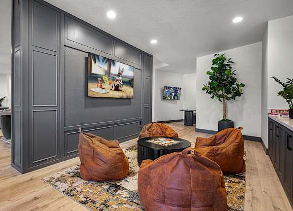 A living room with brown bean bag chairs and a painting on the wall.