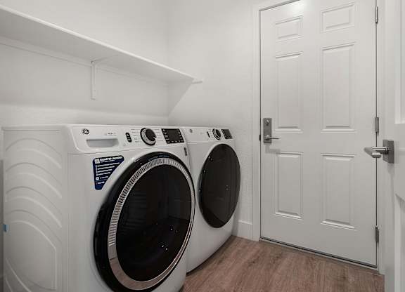 a washer and dryer in a laundry room with a white door