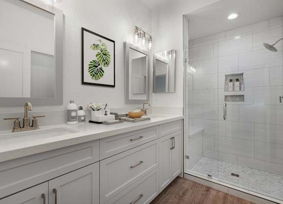 a white bathroom with a shower and a sink
