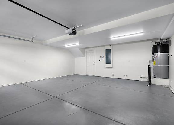 the interior of a white room with a water heater in the corner