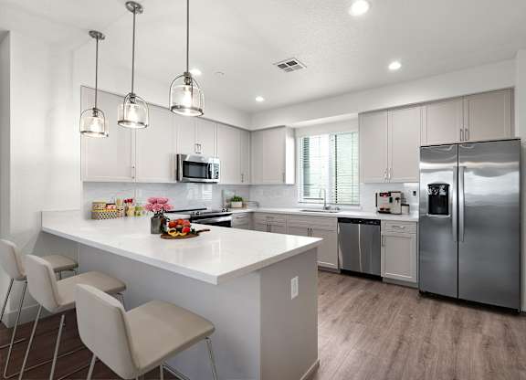 a kitchen with a large island and stainless steel appliances