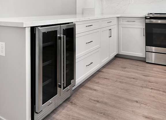 a white kitchen with stainless steel appliances and white cabinets