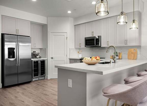a kitchen with a island and stainless steel refrigerator