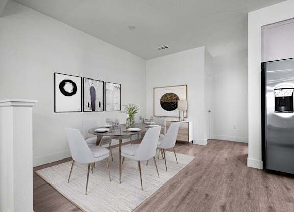 a dining room with a round table and white chairs