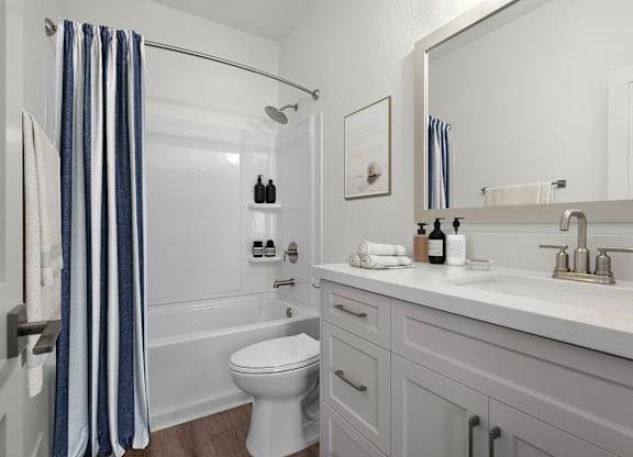 a white bathroom with a shower and a sink and a toilet