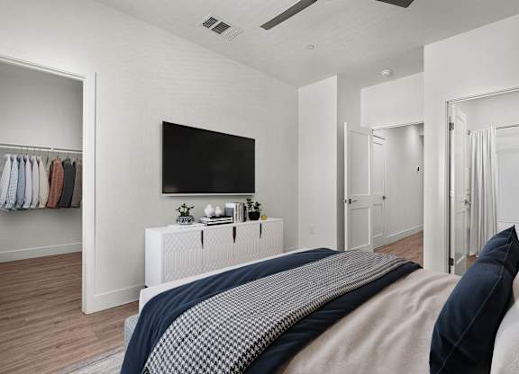 a bedroom with a large bed and a tv on the wall