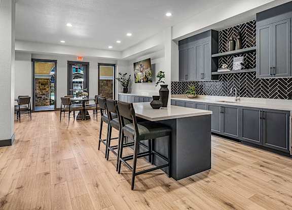 A kitchen with a large island and bar stools.