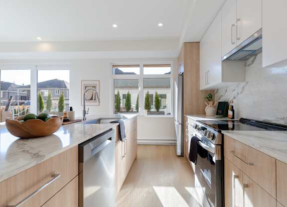 A modern kitchen with wooden cabinets and stainless steel appliances in Hillcrest Ave located in Abbotsford, BC