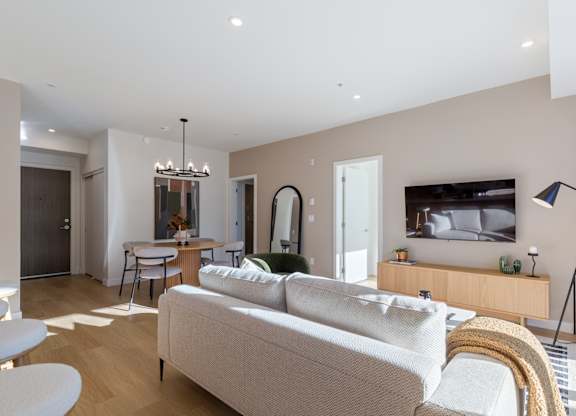 A modern living room with a white sofa and a television in Hillcrest Ave located in Abbotsford, BC