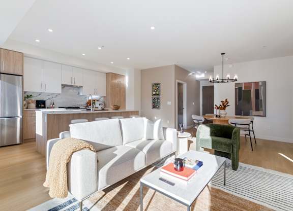 A modern living room with a white couch and a coffee table in Hillcrest Ave located in Abbotsford, BC